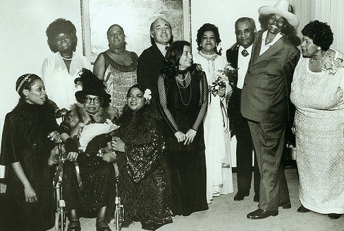 Performers of the 'Blues is a Woman' Concert at the Newport Jazz Festival, Avery Fisher Hall, 1980; (standing, l to r): Koko Taylor, Linda Hopkins, George Wein, Rosetta Reitz, Adelaide Hall, Little Brother Montgomery, Big Mama Thornton, Beulah Bryant; (seated, l to r): Sharon Freeman, Sippie Wallace, Nell Carter; source: https://en.wikipedia.org/wiki/Rosetta_Reitz; photographer: Barbara Weinberg Barefield
