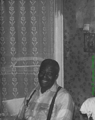 J A M E S   'K O K O M O'   A R N O L D; Kokomo Arnold in his home (4413 South Calumet Avenue) in Chicago, IL, September 1959; source: Jacques Demêtre & Marcel Chauvard: Voyage au Pays du Blues.- Levallois-Perret (CLARB-Soul Bag) 1994, p. 146; photographer: Jacques Demetre