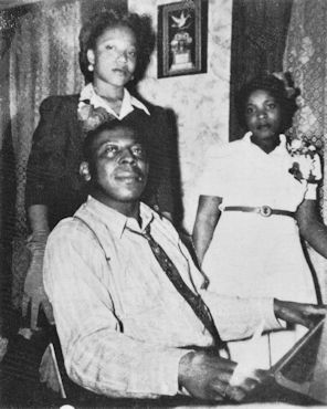 Big Maceo Merriweather with two of his nieces at a party in his home (one source erroneously claims: '... with his daughter Sandra Majorette and a niece' --- If daughter Sandra Majorette has actually been born December 1, 1946 and Big Maceo has (undoubtedly?) died February 26, 1953, the girl could have been maximally three months older than 6 years old on a photo in company with her (still alive!) father, right? None of the two females depicted on that photo looks like they're even close to six years old); source: Lawrence Cohn: Nothing But The Blues.- New York, London, Paris (Abbeville Press) 1993, p. 185 ('Frank Driggs Collection'); photo damages photoshop amended by Stefan Wirz
