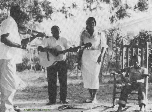 Butch Cage plays fiddle, Willie Thomas plays guitar and Thomas' wife Martha 'pats Juba' in rhythm, Zachary, Louisiana, August 7, 1960; source: Paul Oliver: Savannah Syncopators - African Retentions In The Blues.- London (Studio Vista) 1970; photographer: Paul Oliver; click to enlarge!