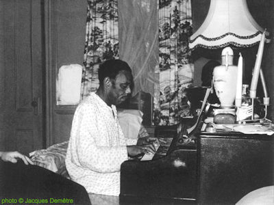 Champion Jack Dupree at home (Pacific Street, Brooklyn, New York), September 1959; source: Paul Oliver: Le Monde du Blues.- Paris (Edition Arthaud) 1962, photo #42, photo pp. between pp. 288 and 289; photographer: Jacques Demêtre