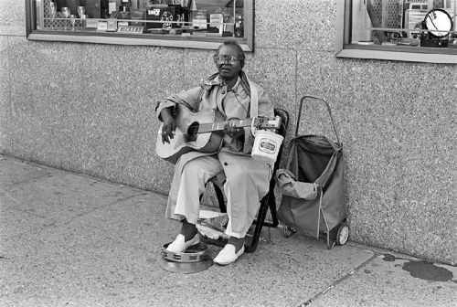 Flora Molton busking in front of the old Woodward and Lothrop store [now H&M] at the corner of 11th St NW & F St NW in Washington, DC, early 1980s; photographer: Steve Green