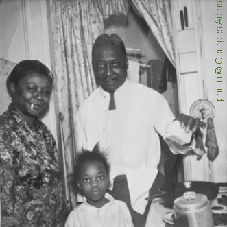 Muddy Waters with his wife Geneva (née Ward, 1915 - March 16, 1973, they married in 1940) and their granddaughter (which they raised) Amelia 'Cookie' Cooper in their home at 4339 South Lake Park in Chicago, Illinois, November 1959; source: Internet; photographer's name not given